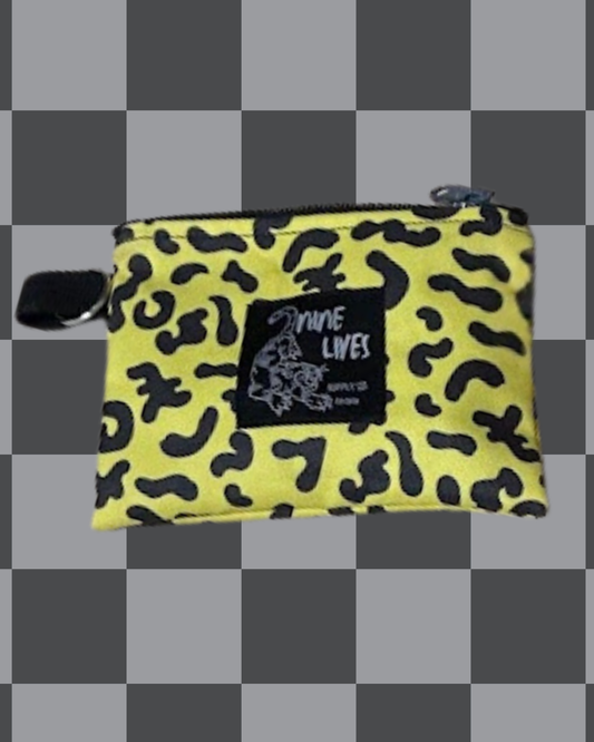 Yellow pouch with black pattern and 'Nine Lives' logo on a checkered background